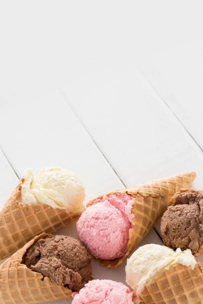 istock Strawberry, Vanilla, and Chocolate Ice Cream in Waffle Cones 1157008935