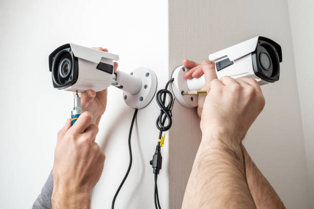 istock Close-up hands of technician adjusting CCTV camera on wall 1157010292