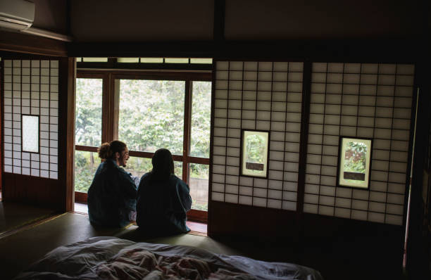Male and female mixed race guests dressed in yukata enjoying a relaxing stay at a traditional Tokyo ryokan.