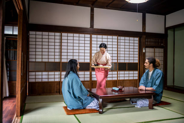 istock Mixed Race Guests and Japanese Server at Tokyo Ryokan 1157010324