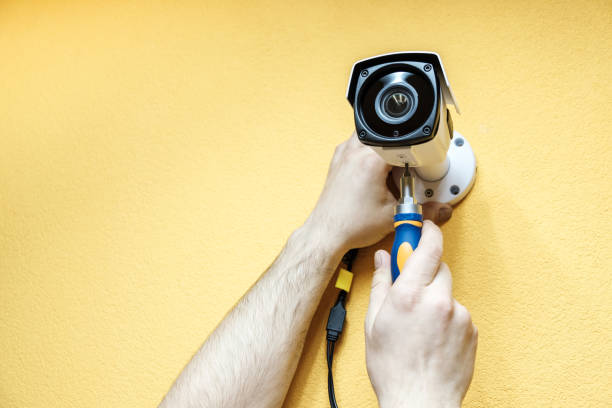 istock Close-up hands of technician adjusting CCTV camera on wall 1157010390