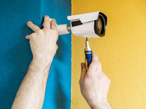 istock Close-up hands of technician adjusting CCTV camera on wall 1157010391
