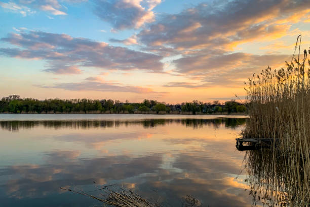 istock Summer landscape of sky and forest reflecting on mirror lake surface. 1157011477