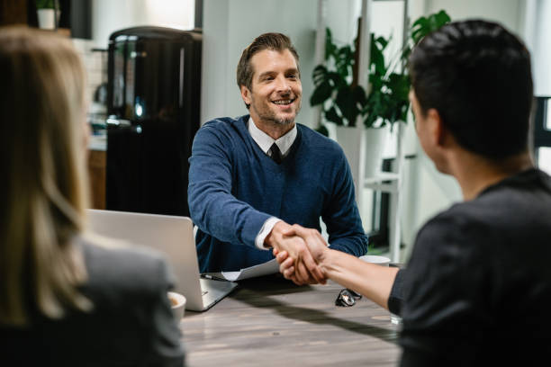 istock Happy financial advisor shaking hands with a couple. 1157013096