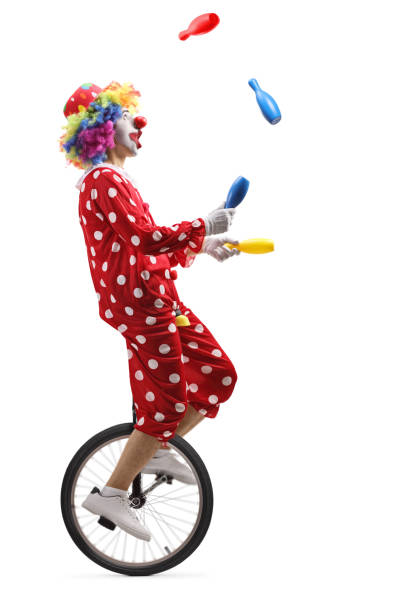 istock Clown on a unicycle juggling with clubs 1157015253