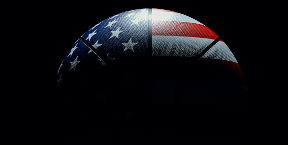 Brightly lit isolated basketball over black background colored like united states flag symbolizing patriotism and competition