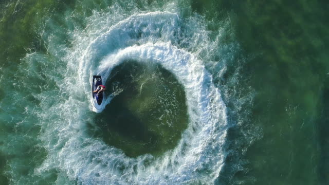 4K straight down zoom out spectacular aerial  view of man having fun riding a personal watercraft in the ocean making a circular pattern, Mozambique