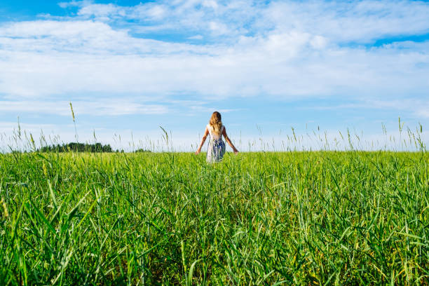 istock Young woman in wheat field. View from the back 1157017005
