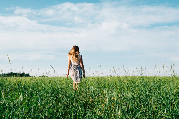 istock Young woman on a wheat field with sunlight 1157017061