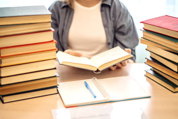istock Young student sitting at desk in home studying and reading, doing homework and lesson practice preparing exam to entrance, education concept. 1157020028
