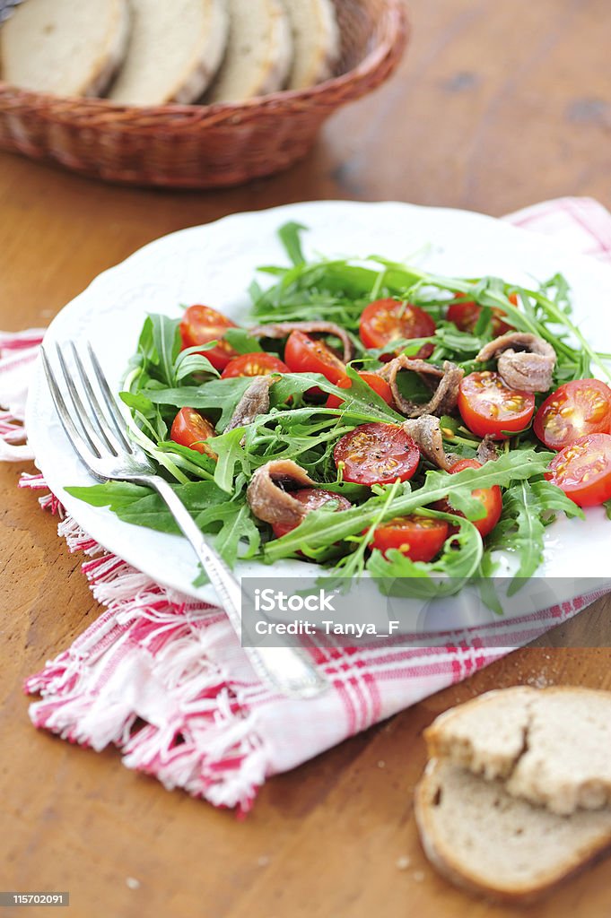 Arugula Salad Rucola, Tomatoes and Anchovy Salad Served with Rye Bread Anchovy Stock Photo