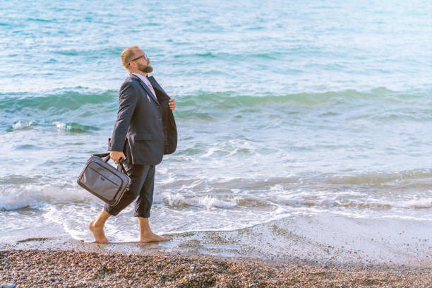 istock Happy businessman walking along the seashore. Vacations Concept 1157021630