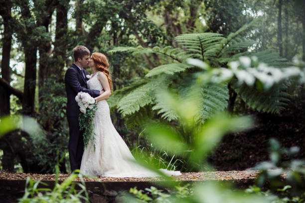 istock Wedding Couple Kissing in Lush Forest 1157021704