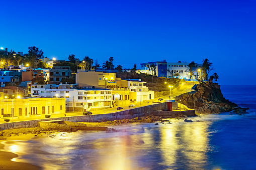 Stock photograph of the illuminated waterfront in Mazatlan, Sinaloa, Mexico at twilight blue hour.