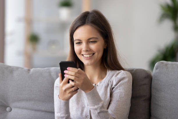 istock Smiling girl hold smartphone receive pleasant text message 1157025869