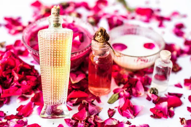 Photo of Face pack or face mask to nourish and moisturises  skin isolated on white i.e. Rose essential oil well mixed with coconut oil,olive oil and milk in a glass bowl and entire raw ingredient present.