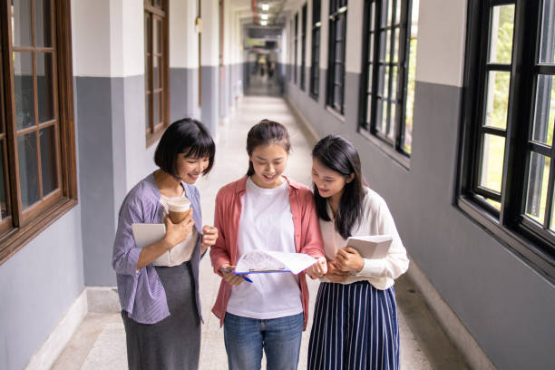 istock Three Asian student reading report together in school building 1157026744