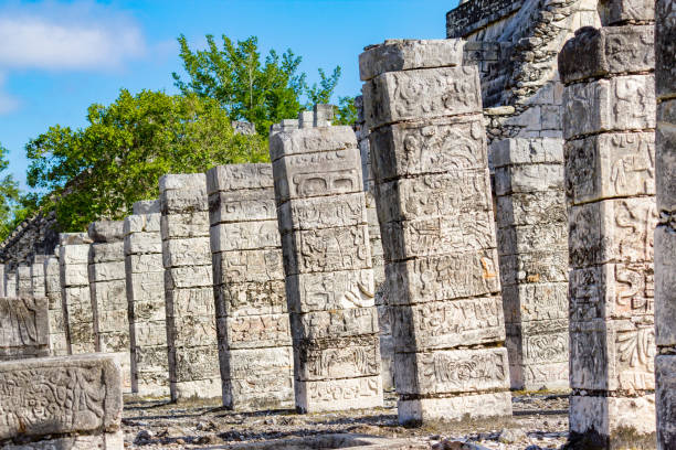 Stock photograph of ornate carved columns at Chichen Itza, Mexico on a sunny day.