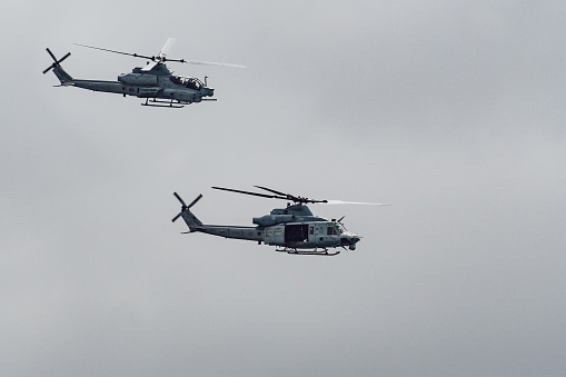 June 14, 2019 Pescadero / CA / USA - Two Marines Helicopters flying close to the Pacific Ocean coastline; cloudy sky background