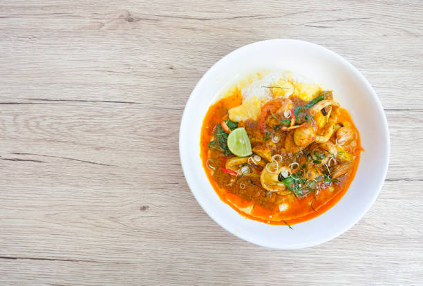 istock Stir fried chilli, shrimp, squid, sea shells wrapped in thick eggs in a white dish on a wooden background from top view. 1157033792