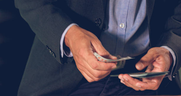 istock Asian Businessmen count money and plan finances for projects and use calculators for analysis project documents and graph financial diagram working in the background on office table 1157036656