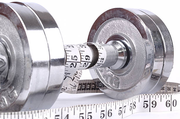 istock pair of weights with measuring tape on white background 115703703