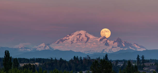 montagna di neve con piena luna al tramonto - mountain snow sunset house foto e immagini stock