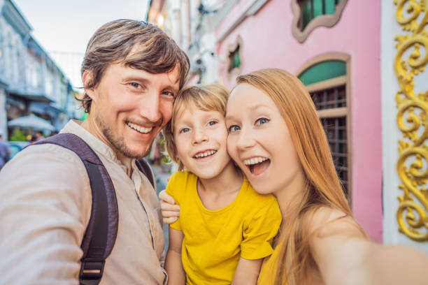 Mom, Dad and Son tourists on the Street in the Portugese style Romani in Phuket Town. Also called Chinatown or the old town. Traveling with kids concept Mom, Dad and Son tourists on the Street in the Portugese style Romani in Phuket Town. Also called Chinatown or the old town. Traveling with kids concept. driveway colonial style house residential structure stock pictures, royalty-free photos & images