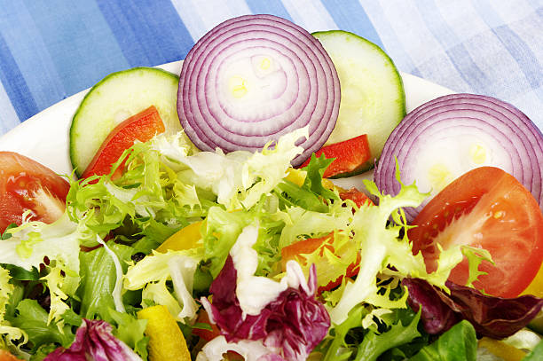 Bowl of mixed salad on blue gingham cloth 