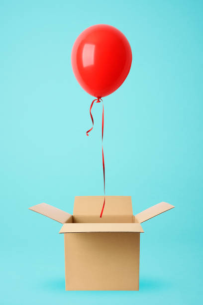 Red balloon floating from a cardboard box