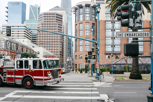 Buildings, streets and palm trees in San Francisco, California. A fire truck can be seen passing by.