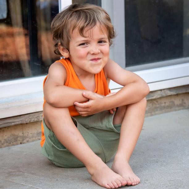 Caucasian Smiling three years old child boy looking at the camera sitting on the floor