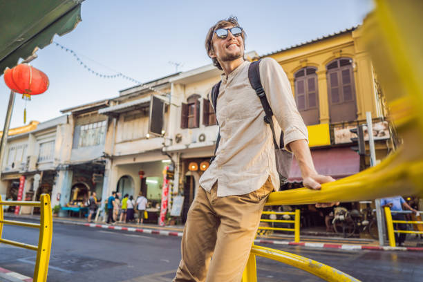 Man tourist on the Street in the Portugese style Romani in Phuket Town. Also called Chinatown or the old town Man tourist on the Street in the Portugese style Romani in Phuket Town. Also called Chinatown or the old town. driveway colonial style house residential structure stock pictures, royalty-free photos & images