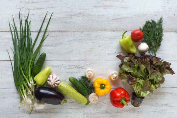 istock Vegetables are laid out on a white wooden table. 1157040737