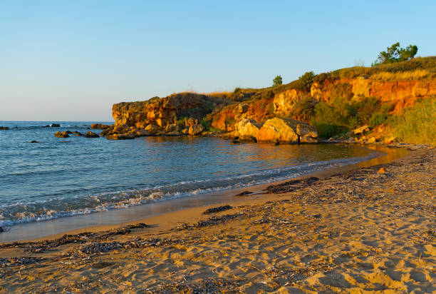 linea costiera con scogliera al tramonto. - greece crete beach island foto e immagini stock