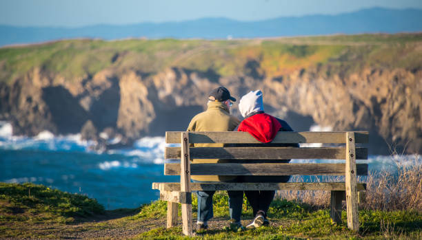 istock Senior couple sitting in a bench contemplating the cliff 1157043365