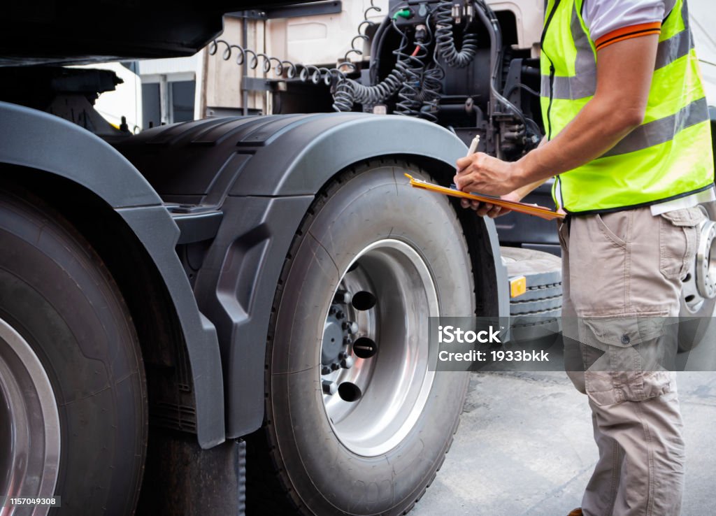 Truck inspection and safety Truck driver is inspecting check truck wheels. Truck Stock Photo
