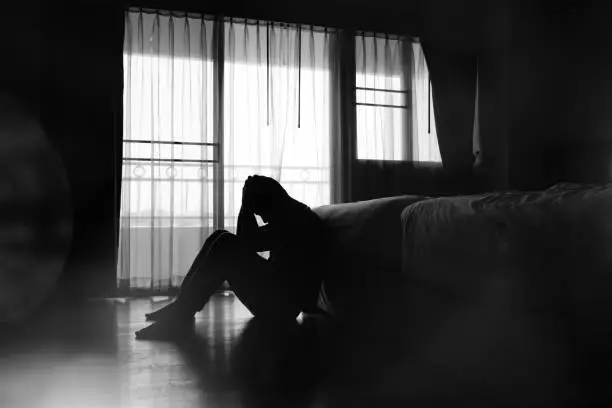 Silhouette of depressed man sitting in the private room