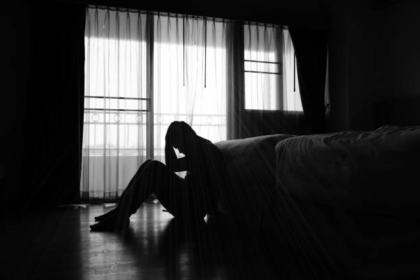 Asian man Silhouette of depressed man sitting in the private room depression sadness stock pictures, royalty-free photos & images