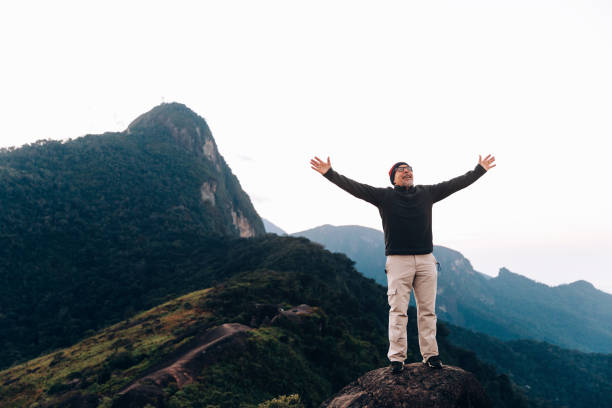 istock Senior man with arms raised cheering outdoors at the mountain 1157051452