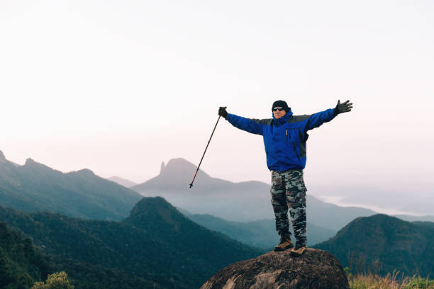 istock Senior man with arms raised cheering outdoors at the mountain 1157051562
