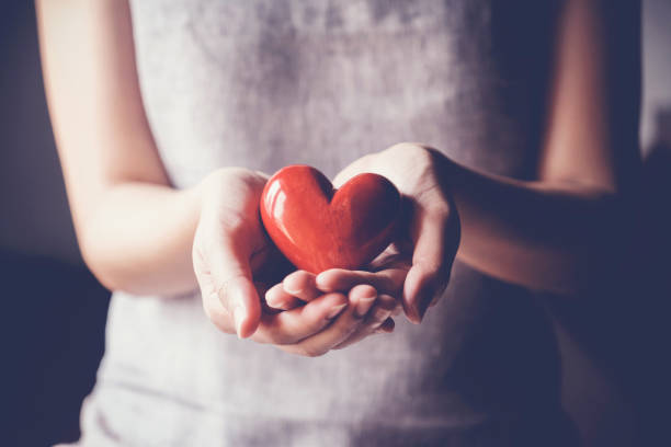 woman holding red heart, ziektekostenverzekering, donatie liefdadigheid concept - love hand sign stockfoto's en -beelden