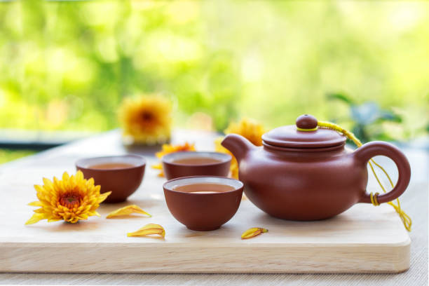 식탁에 차와 찻잔, 국화 꽃을 장식으로 장식하고 정원에서 휴식을 취하십시오. 건강한 생활 개념, - chinese tea 뉴스 사진 이미지