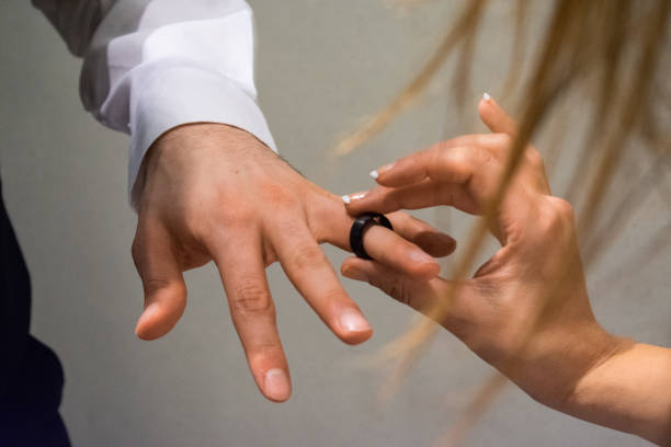 istock Bride putting ring on groom's finger 1157053365