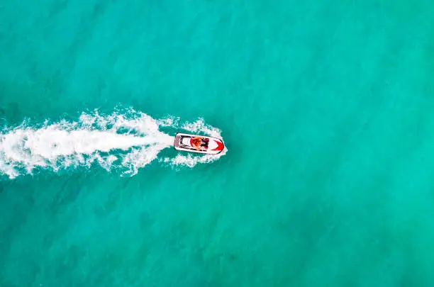 Beautiful Aerial View jet ski in sea. Entertainment on water bikes in sea turquoise water. Tourists have fun on vacation. Aerial view. Top view. People are playing a jet ski. amazing nature background