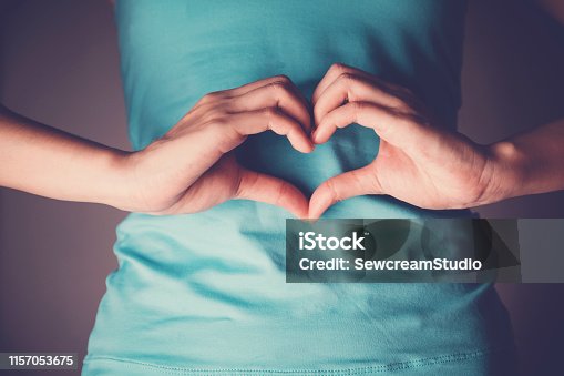 istock Woman hands making a heart shape on her stomach, healthy bowel degestion, probiotics  for gut health 1157053675