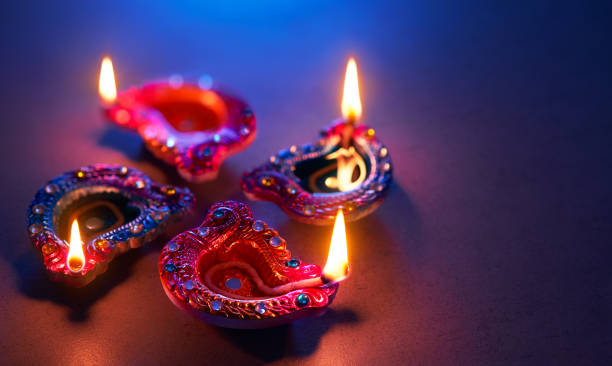 istock Happy Diwali - Diya lamps lit during diwali celebration 1157054670
