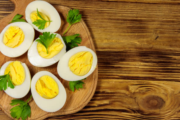 istock Boiled eggs with parsley on cutting board on a wooden table. Top view 1157056268