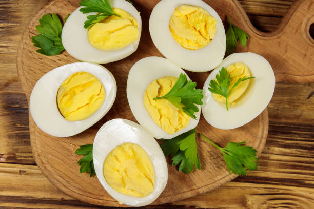 istock Boiled eggs with parsley on cutting board on a wooden table. Top view 1157056270