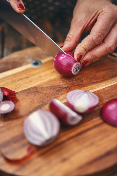 istock Cutting Onions on Wooden Cutting Board 1157056456